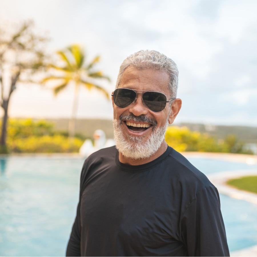 The essence of exceptional living a man wearing sunglasses by the pool